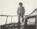 Image of Second Mate D. Norman standing beside rail. "Cluett". Off Disko Island