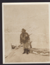 Image of Jot dressed for Hare [Expedition member in furs with rifle. Two sledges]