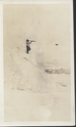 Image of Inuit(?) man on snow mound, using telescope