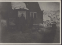 Image of Man standing on steps of frame house
