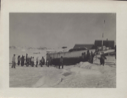 Image of Group of West Greenlanders by large, beached boat. Ropes attached