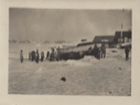 Image of Group of West Greenlanders by large, beached boat. Ropes attached