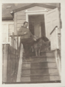 Image of White man with dogs, on church steps