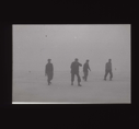 Image of Four crewmen walking across snow  [b&w]