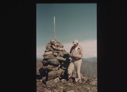 Image of Crewman beside cairn, reading record 