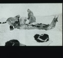 Image of Five men repairing sledge. Dogs at rest in foreground [from a book]