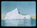 Image of Iceberg with hole. People standing on base