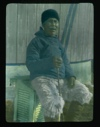 Image of Merk-to-shar, oldest man in the tribe, sittiing on louvered box ...             