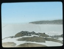 Image of Ice sheet on sea. Rocks in foreground