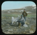 Image of Lange Koch (standing) and Elmer Ekblaw (sitting on rock)  with dog 