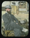 Image of Maurice Tanquary at Borup Lodge, seated outside, wearing dress suit