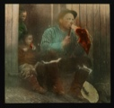 Image of Maurice Tanquary (?) sitting on steps - eating meat Inuit manner....