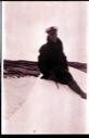 Image of Man sitting on snow or ice with ice ax