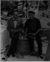 Image of ? and Donald MacMillan sitting on a coil of rope on the BOWDOIN's deck after arriving in Mystic