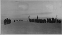 Image of Large group of men on snow with flags, cameras; some wear polar bear pants. Soviet Polar Expedition