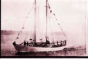Image of The BOWDOIN. Two people wave from the bow 