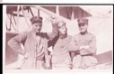 Image of Three men stand beside plane. One waves