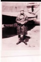 Image of Man in aviator's long coat standing by plane