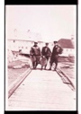 Image of Three men standing on ramp. Eugene McDonald in dark hat. Two hold snowshoes. McDonals holds other equipment