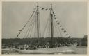Image of The schooner BOWDOIN, dressed with guests aboard, in the harbor