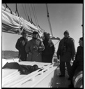 Image of Eskimo [Inuk] pilot and after-deck group, with cameras and warm coats