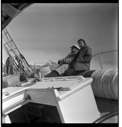Image of "Shipwreck photo" - MacMillan and Miriam sit on tilted deck near hatch