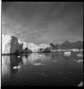 Image of Large iceberg, ice floes, mountains