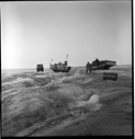 Image of Three vehicles, men and a barrel on Greenland ice cap
