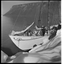 Image of BOWDOIN tied to iceberg, crew on bow