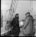 Image of French priest at Pond Inlet on deck with crew