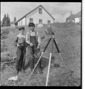 Image of Two "livyer" boys stanging by camera tripod, on a hill
