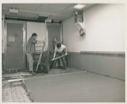 Image of Two men preparing new flooring, Thule AFB