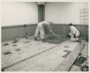 Image of Two men smooth concrete for new floor, Thule AFB