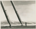 Image of Man standing by two antenna struts,