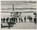 Image of Men with sledge and dog on tarmac near airplane