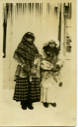 Image of Two Innu Women in Winter Clothing Standing outside Building