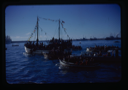 Image of Small ships packed with crowds of people.