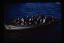 Image of Rowboat packed with people.