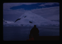 Image of Man on ship deck looking at snow covered hill