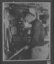 Image of [Bartlett] below deck with rifle, wearing polar bear pants [bedford pennant]