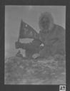 Image of Borup holding Yale pennant, on land