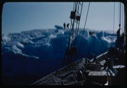 Image of Bowdoin against iceberg; crew on the ice