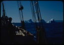 Image of Iceberg through rigging; Donald MacMillan on deck