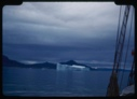 Image of Iceberg beyond rigging; storm clouds