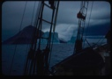Image of Icebergs through rigging; storm clouds
