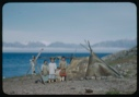 Image of Three Eskimo [Inuit] women and a child by sealskin tent