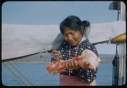 Image of Inawahoo cutting meat with ooloo, on Bowdoin
