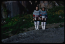 Image of Two Eskimo [Inuit] women in traditional dress, by wildflowers