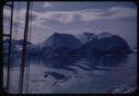 Image of Snow-covered coastal mountains through rigging, with water swirls