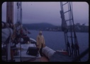 Image of Donald MacMillan on deck, in slicker. First view of Labrador